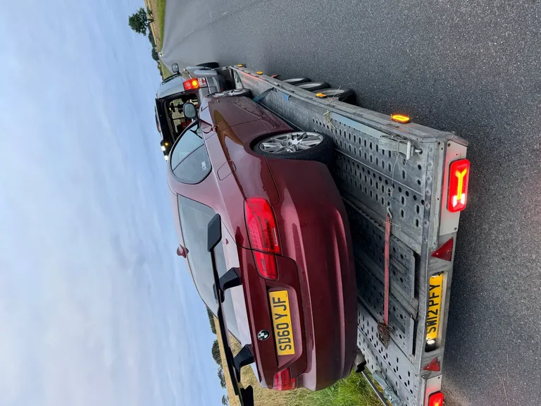 Maroon BMW coupe on the DSBM trailer, rural road
